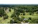 Stunning aerial view of a golf course community featuring mature trees, a pond, and beautiful homes at 127 Grandmar Chase, Canton, GA 30115