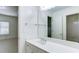Clean bathroom with white vanity, mirror, and a view into the tile surround combination shower and tub at 127 Grandmar Chase, Canton, GA 30115