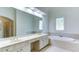 Bathroom featuring double sinks, a large mirror, and a luxurious soaking tub at 127 Grandmar Chase, Canton, GA 30115