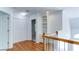 Hallway view with hardwood floors, white trim, built-in shelving, and access to a bedroom with natural light at 127 Grandmar Chase, Canton, GA 30115