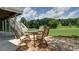 Covered outdoor patio with a table and chairs overlooking a lush backyard at 127 Grandmar Chase, Canton, GA 30115