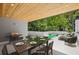 Virtually staged dining and lounge area with putting green on the covered deck with recessed lighting at 1287 Star Ne Dr, Brookhaven, GA 30319