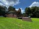 A backyard with a brick house, green grass, trees and a patio at 199 Mckaskey Creek Se Rd, Cartersville, GA 30121