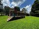 A backyard with a brick house, green grass, trees and a patio at 199 Mckaskey Creek Se Rd, Cartersville, GA 30121