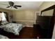 A bedroom with hardwood floors, a ceiling fan, and a large mirror on a chest at 199 Mckaskey Creek Se Rd, Cartersville, GA 30121