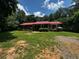 Charming single-story home with a red roof and lush, mature trees surrounding the property at 199 Mckaskey Creek Se Rd, Cartersville, GA 30121