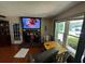 Cozy living room featuring a brick fireplace, hardwood floors, and natural light from a large window at 199 Mckaskey Creek Se Rd, Cartersville, GA 30121