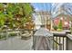 Outdoor deck featuring a built in fire pit, grilling area, and distant view of neighboring houses at 49 Conifer Park Ln, Atlanta, GA 30342