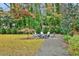 A backyard featuring an outdoor fire pit with Adirondack chairs on a manicured lawn, perfect for entertaining guests at 49 Conifer Park Ln, Atlanta, GA 30342