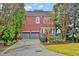 Two-story red brick home with a two car garage, manicured landscaping, and a private deck at 49 Conifer Park Ln, Atlanta, GA 30342