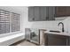Stylish wet bar featuring gray cabinets, a beverage cooler, a modern sink, and a bright window at 49 Conifer Park Ln, Atlanta, GA 30342