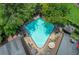 Aerial view of a community pool with sun loungers and umbrellas, surrounded by greenery at 1105 Clairemont Ave # J, Decatur, GA 30030