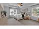 Primary bedroom showcasing tray ceiling, ceiling fan, large windows, and neutral decor at 1311 Park Center Cir, Austell, GA 30168