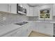 Renovated kitchen has new white cabinets, stainless appliances, and gray backsplash at 1770 Austin Dr, Decatur, GA 30032