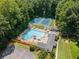 Aerial shot of community pool with lounge chairs and umbrellas and blue tennis courts in a wooded setting at 2941 Foothill Trl, Marietta, GA 30066