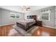 Primary bedroom with a ceiling fan, wood floors, and a large bed with dark wood furnishings at 2941 Foothill Trl, Marietta, GA 30066