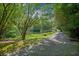 Scenic driveway leading to a home surrounded by mature trees and lush greenery with a tranquil pond view at 2941 Foothill Trl, Marietta, GA 30066