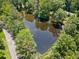 Aerial view of a tranquil pond surrounded by lush greenery and mature trees, adding to the property's charm at 2941 Foothill Trl, Marietta, GA 30066