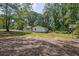 View of the home's backyard featuring mature trees and open space on a bright sunny day at 995 Highway 101 S, Temple, GA 30179