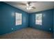Blue bedroom with two windows, neutral carpet, and a ceiling fan at 995 Highway 101 S, Temple, GA 30179