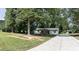 Quaint one-story home with charming front porch and shuttered windows surrounded by mature trees on a spacious lot at 995 Highway 101 S, Temple, GA 30179