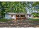 Quaint one-story home with charming front porch and shuttered windows surrounded by mature trees on a spacious lot at 995 Highway 101 S, Temple, GA 30179