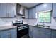 Bright kitchen features stainless steel appliances, granite countertops, and modern gray cabinetry at 995 Highway 101 S, Temple, GA 30179