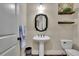 Charming powder room featuring a pedestal sink, decorative mirror, and stylish shelving at 4256 Weaver Se St, Smyrna, GA 30080