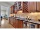 Butler pantry featuring rich wood cabinetry, granite counters, and a wine refrigerator at 4256 Weaver Se St, Smyrna, GA 30080