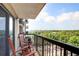 Condo balcony with rocking chairs and scenic views of trees and a parking lot at 795 Hammond Dr # 1012, Atlanta, GA 30328