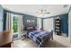 Charming bedroom featuring blue walls, hardwood floors, and a window letting in natural light at 1622 Gates Nw Pl, Atlanta, GA 30318
