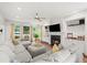 Bright living room features a fireplace, large sectional sofa, ceiling fan and views to the outdoors at 1622 Gates Nw Pl, Atlanta, GA 30318