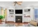Comfortable living room features a fireplace, built-in shelving, and a ceiling fan for a cozy atmosphere at 1622 Gates Nw Pl, Atlanta, GA 30318