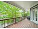 Spacious covered patio with wood floors, a grill, and view of the wooded surroundings at 1622 Gates Nw Pl, Atlanta, GA 30318