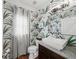 Stylish powder room featuring palm-leaf wallpaper, granite countertop, vessel sink, and hardwood floors at 1622 Gates Nw Pl, Atlanta, GA 30318