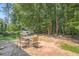 A serene backyard featuring mature trees, a patio with an outdoor dining set, and a grill at 8767 N View Dr, Lithia Springs, GA 30122
