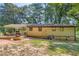 View of the rear of the house with a brick patio, grill, partially enclosed porch, and fenced area at 8767 N View Dr, Lithia Springs, GA 30122