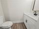 Stylish half bathroom with modern vanity, black fixtures, and wood-look floors at 2335 Azalea Dr, Loganville, GA 30052