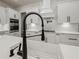 Well-equipped kitchen boasts white cabinets, black hardware, stainless appliances, and a farmhouse sink at 2335 Azalea Dr, Loganville, GA 30052