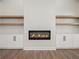 Modern living room featuring a fireplace, built-in shelves and cabinets, and wood flooring at 2335 Azalea Dr, Loganville, GA 30052