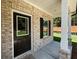 Inviting front porch features a brick facade, white columns, and a stylish front door with a window at 45 Heyman Dr, Covington, GA 30016