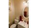 Powder room featuring a white vanity, oval mirror, and decorative accents at 640 Dahoma Trl, Woodstock, GA 30188