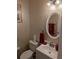 Powder room featuring a white vanity, oval mirror, and decorative accents at 640 Dahoma Trl, Woodstock, GA 30188