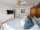 This bedroom features carpeted floors, a ceiling fan, and a large bed with built in headboard storage at 640 Dahoma Trl, Woodstock, GA 30188