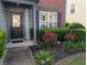 Welcoming front entrance with a black door, neatly trimmed hedges, and colorful flowerbeds at 640 Dahoma Trl, Woodstock, GA 30188