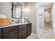 Stylish bathroom with dark vanity, marble countertop, decorative mirror, and a tiled walk-in shower for a luxurious experience at 150 Seals Rd, Dallas, GA 30157