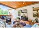 Cozy covered deck featuring a TV, comfortable seating, potted plants, and a ceiling with recessed lighting for outdoor enjoyment at 150 Seals Rd, Dallas, GA 30157