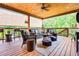 Inviting covered deck with wood ceiling, wicker furniture, stylish pillows, and privacy blinds for outdoor comfort and relaxation at 150 Seals Rd, Dallas, GA 30157