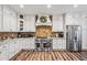Spacious kitchen featuring white cabinetry, stainless steel appliances, and a unique brick backsplash at 150 Seals Rd, Dallas, GA 30157
