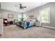 Serene main bedroom with large windows, neutral tones, a ceiling fan, and comfortable seating for a peaceful retreat at 150 Seals Rd, Dallas, GA 30157